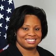 Smiling person with American flag backdrop